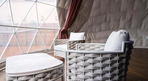 two chairs and a stool in a room with a window at Hotel Tango Kingdom in Amino