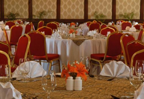 a dining room with white tables and red chairs at Rajasthali Resort & Spa in Jaipur