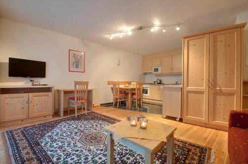 a living room with a table and a kitchen at Apart Ehart in Sankt Anton am Arlberg