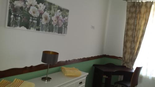 a room with a table with a lamp and flowers on the wall at Luxury Central apartment in Sibiu in Sibiu