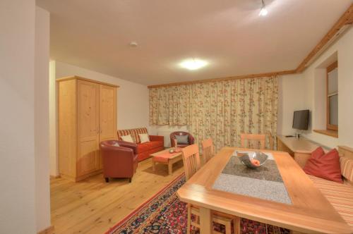 a living room with a table and a couch at Apart Ehart in Sankt Anton am Arlberg
