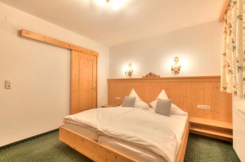 a bedroom with a bed with a wooden headboard at Apart Ehart in Sankt Anton am Arlberg