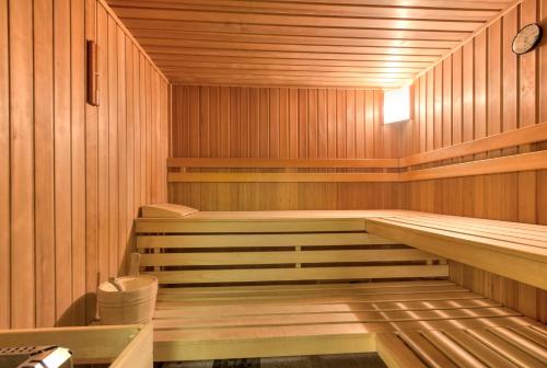 a sauna with wooden walls and wooden floors and a tub at Apart Ehart in Sankt Anton am Arlberg