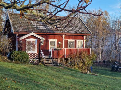 トローサにあるMysigt boende nära hav och naturの草の丘の上の赤い家