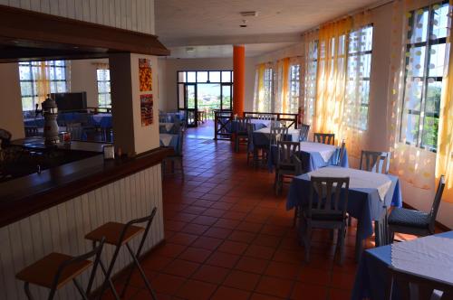 a dining room with tables and chairs and windows at Estalagem Corte do Norte in Ponta Delgada