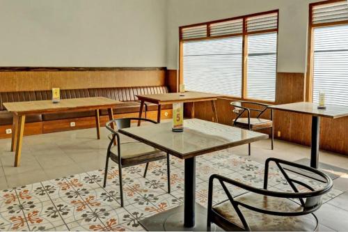 ein Klassenzimmer mit Tischen und Stühlen in einem Raum in der Unterkunft Capital O 1362 Ciliwung Guest House Syariah in Malang