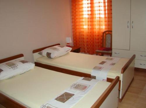 two beds in a small room with a room with at Apartments Snježana in Sali