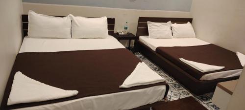 马哈巴利普拉姆MK Beach day的配有衬衫的小客房内的两张床