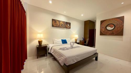 een slaapkamer met een bed en een rood gordijn bij Baan Phu Chalong Place in Ban Suan