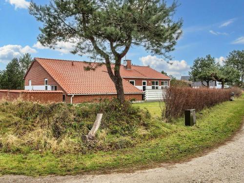 a house with a tree in front of it at Seaside Retreat with Pool - By Traum Ferienwohnungen in Fjellerup