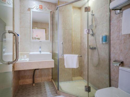 une salle de bain avec une douche en verre et un lavabo dans l'établissement Vienna 3 Best Hotel Shenzhen Shazui Road Branch, à Shenzhen
