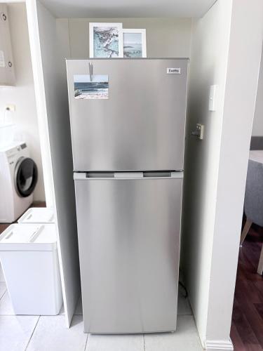 a refrigerator in a kitchen with a white wall at Coastal Comfort In The Heart Of Coogee in Sydney