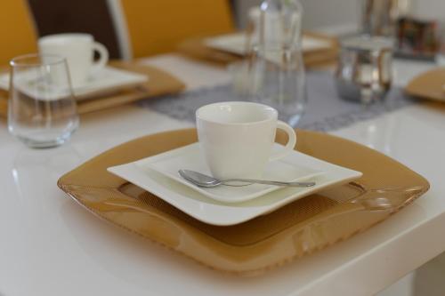 a coffee cup on a plate on a table at Villa Quality Wellness in Dozmat