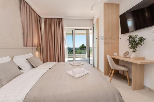 1 dormitorio con 1 cama grande, escritorio y ventana en Villa Axia Šibenik, en Šibenik