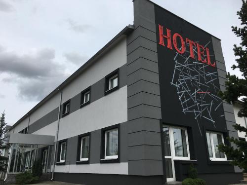 a black and white building with a hotel sign on it at Canpol-Jull's Art Hotel in Człuchów