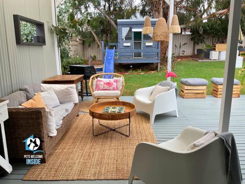 a patio with couches and chairs and a table at Saltwater Sunsets Seaside Haven with Ocean Views in Victor Harbor