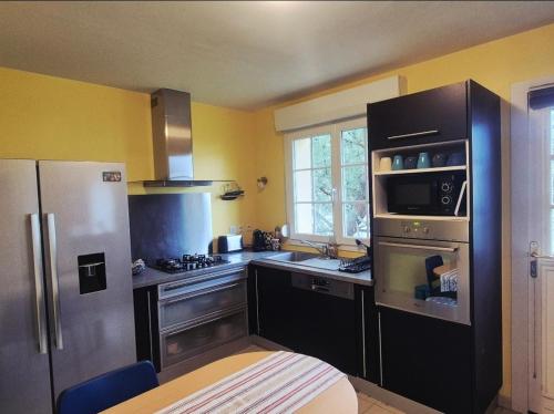 Il comprend une cuisine équipée d'un réfrigérateur en acier inoxydable et d'une cuisinière. dans l'établissement Les sables, à Le Touquet-Paris-Plage