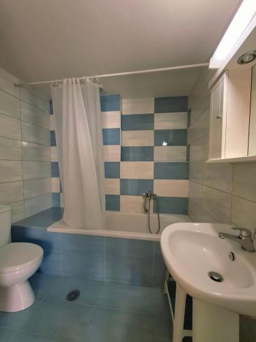 a bathroom with a sink and a toilet and a shower at 4S Beach Superior Apartments in Stalís