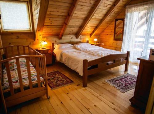 a bedroom with a bed in a wooden cabin at Wooden House Vučedol in Vukovar
