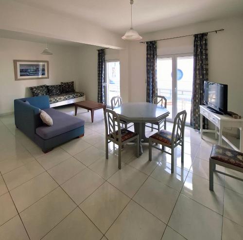 斯塔里斯4S Beach Superior Apartments的客厅里有一张蓝色的沙发和一张桌子