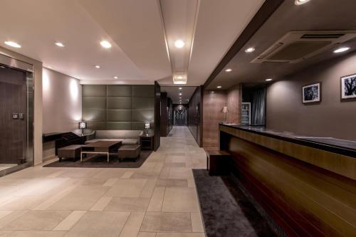 a lobby with a bar and a waiting room at Hotel Vista Kumamoto Airport in Ozu