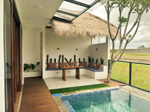 eine Villa mit Pool, Tisch und Dach in der Unterkunft LaVella Villa Jogjakarta kolam renang pribadi in Godean