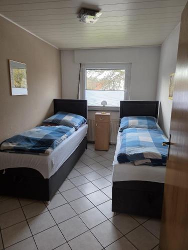 two beds in a room with a window at Ferienwohnung Beate & Burkhard in Oberhausen