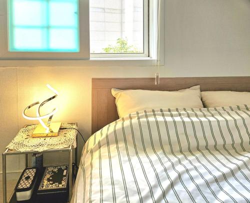 a bedroom with a bed and a table with a lamp at Namsan Nest in Seoul