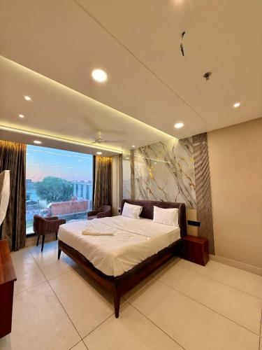 a bedroom with a large bed and a large window at Hotel Amora Royale in Jāmb