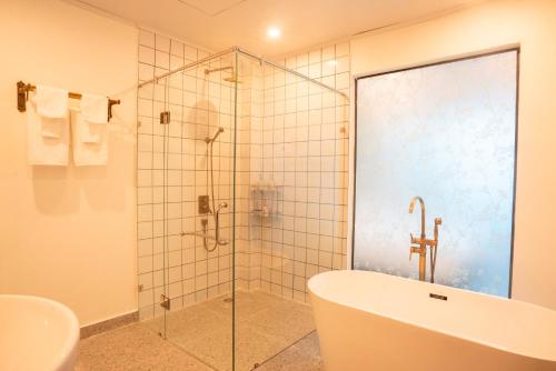 a bathroom with a shower and a tub and a sink at The Green Hotel Vientiane in Vientiane