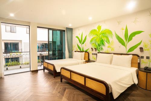 a bedroom with two beds and a balcony at The Green Hotel Vientiane in Vientiane