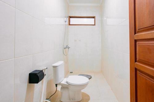 Un baño blanco con inodoro y teléfono. en Nice Villa In Seminyak #YoNa, en Seminyak