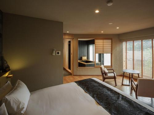 a bedroom with a large white bed and a table at Hakone Hibarino hot spring hotel in Hakone
