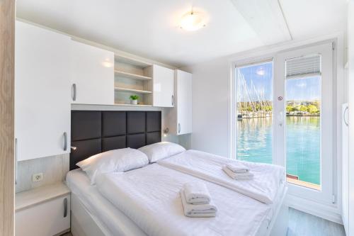 a bedroom with a bed with a view of the water at Lovely HouseBoat Apartment Portorose in Portorož