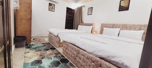 two twin beds in a room with a floor at pyramids dreams in Cairo
