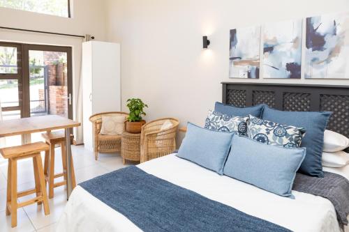 a bedroom with a bed and a table and chairs at Studio 51 in Port Alfred