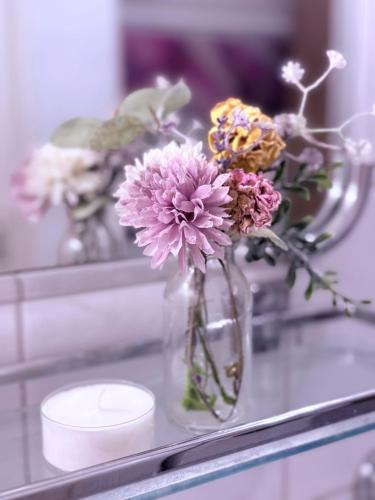a glass vase filled with flowers on a shelf at Indigena Forest Retreat -Entire 6 persons Family home near Efteling and Dunes in Sprang-Capelle