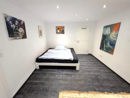 ein Schlafzimmer mit einem Bett in einem Zimmer mit Gemälden in der Unterkunft Modern habitable gallery, centrally located in Hirschaid in Hirschaid