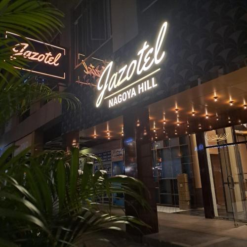 a sign on the side of a building with lights at Jazotel Batam in Jodoh