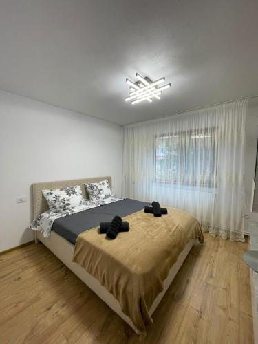 a bedroom with a bed and a large window at Tilia Appartment in Craiova
