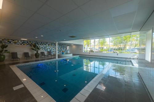 a large swimming pool in a building at Stylish chalet in nature near Amsterdam in Halfweg