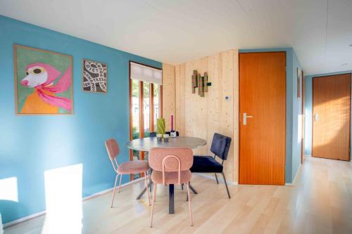 a dining room with a table and chairs at Kleurrijk boshuisje Sole op de Veluwe in Putten