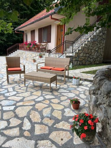 a patio with benches and flowers in front of a house at Vikendica Silenzio in Cetinje