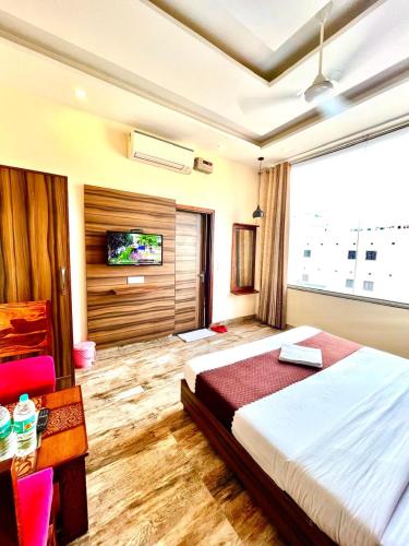 a bedroom with a bed and a desk and a tv at Hotel WoodCrest Chandigarh Zirakpur in Chandīgarh