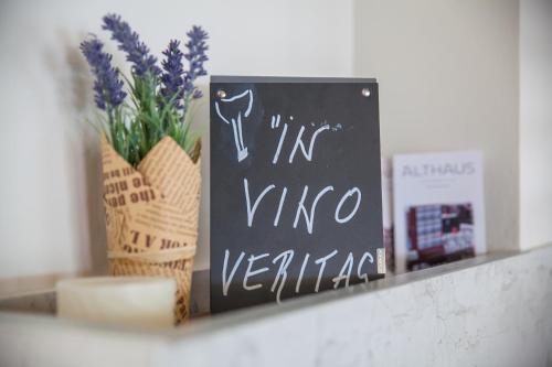 a chalkboard sign on a shelf with a vase of flowers at Hotel Casa del Mare - Blanche in Herceg-Novi