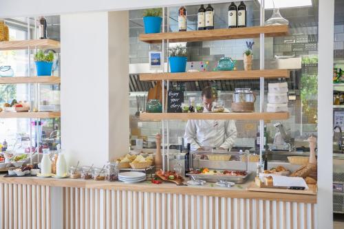 a kitchen with a chef behind a counter with food at Hotel Casa del Mare - Blanche in Herceg-Novi