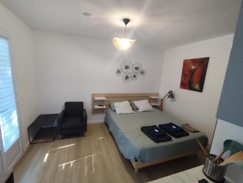une petite chambre avec un lit et une chaise dans l'établissement Studio with garden and pool, easy Nîmes access, à Caissargues