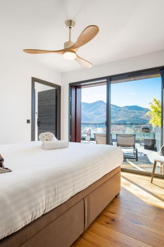 a bedroom with a large bed with a ceiling fan at Les Restanques du lac in La Chapelle