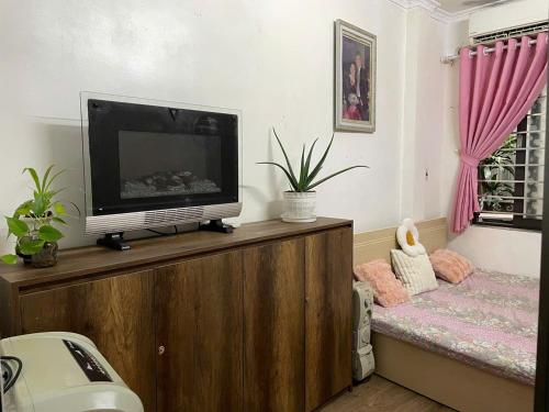 un salon avec une télévision sur un support en bois dans l'établissement TayHo Rose202 Homestay, à Hanoï