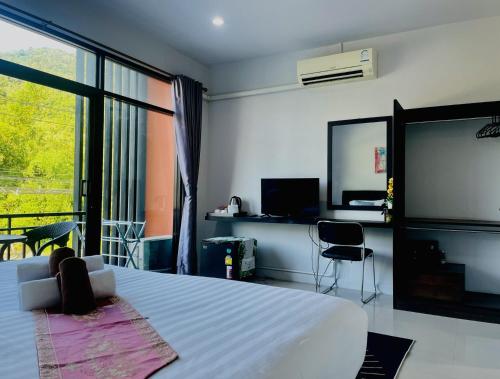 a bedroom with a bed and a flat screen tv at Mr.T Kamala Room in Kamala Beach